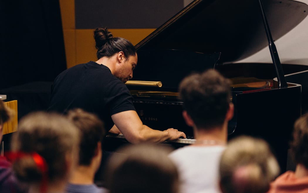 Composer plays grand piano