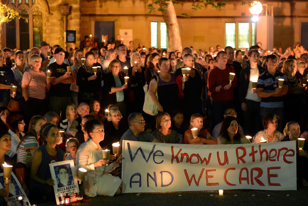 People attend a candlelight vigil in support of asylum seekers, in Sydney on February 23, 2014.