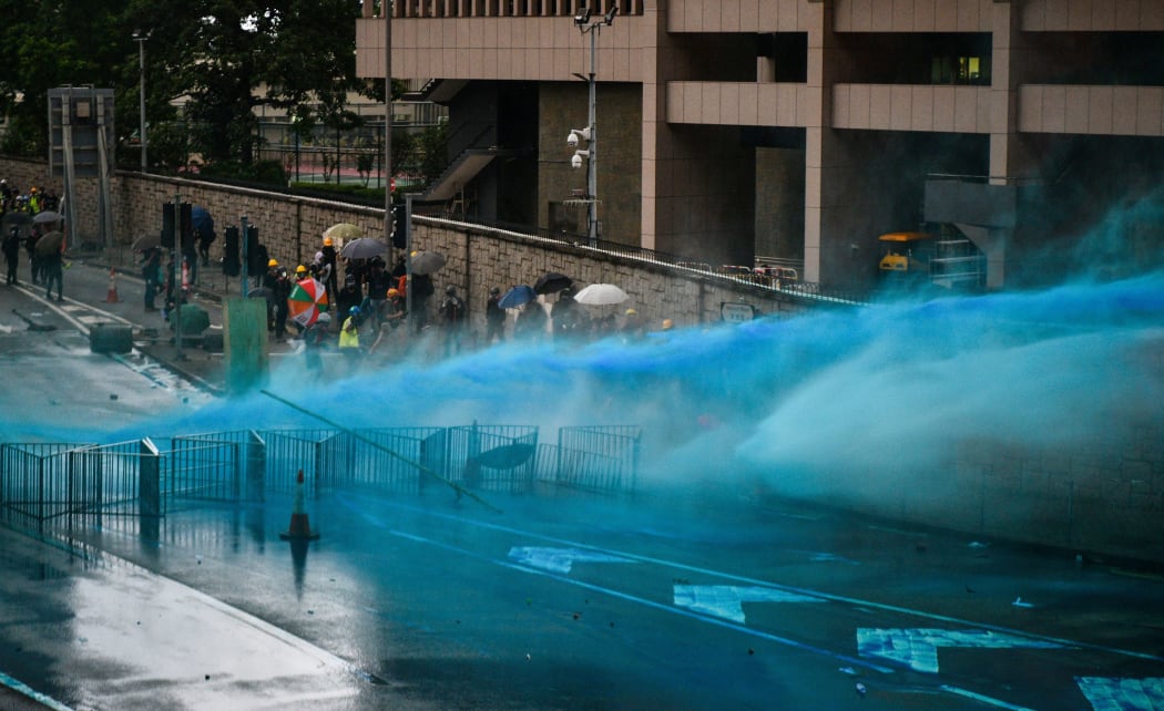 Police fire a water cannon towards protesters near the government headquarters in Hong Kong on August 31, 2019.