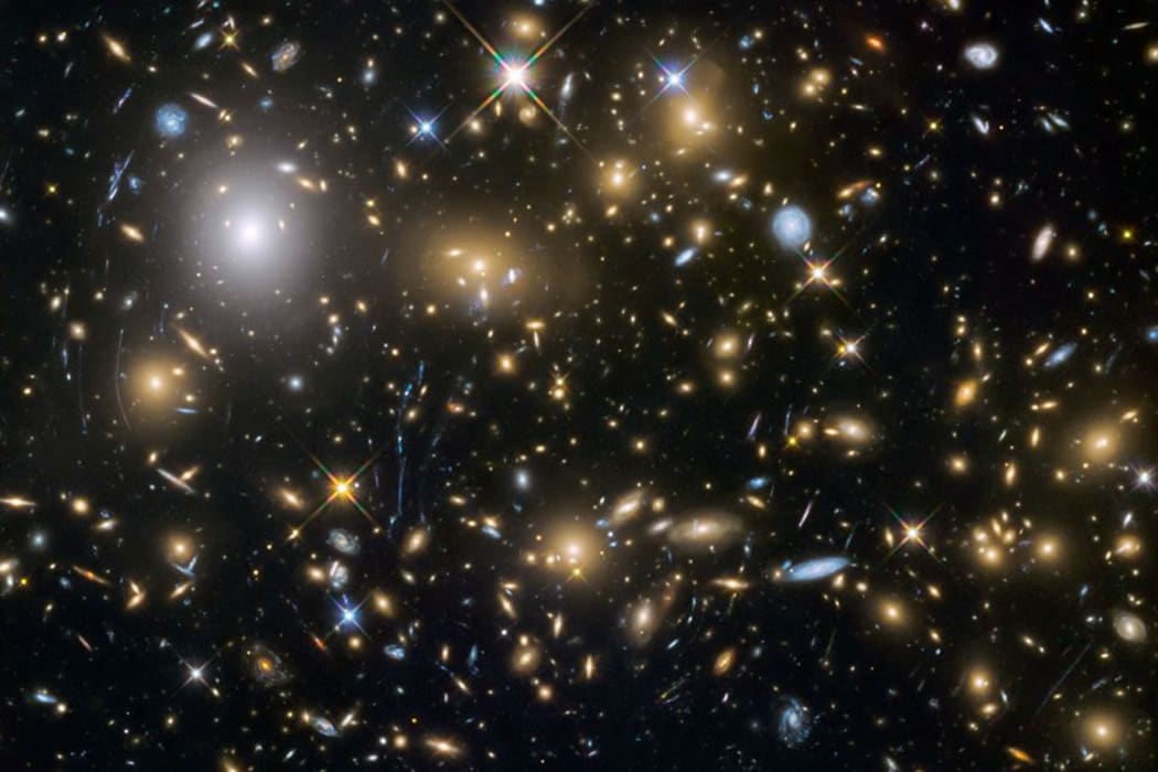 Astronomers use the Hubble Space Telescope and Albert Einstein's General Theory of Relativity to obtain gravitational lensing images of galaxy cluster.