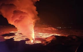 Billowing smoke and flowing lava are seen pouring out of a new fissure in this Icelandic Department of Civil Protection and Emergency Management , February 8, 2024, handout image during a new volcanic eruption on the outskirts of the evacuated town of Grindavik, western Iceland. A volcanic eruption started on the Reykjanes peninsula in southwestern Iceland on Thursday, the third to hit the area since December, authorities said. (Photo by Icelandic Department of Civil Protection and Emergency Management / AFP)