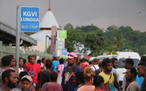 People at a bus stop in Honiara, Solomon Islands