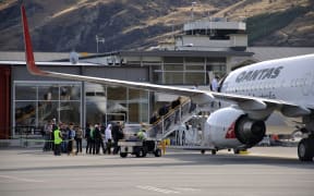 Passengers board commercial jet at Queenstown Airport.
