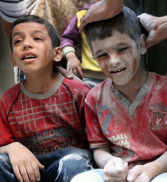 Syrian boys cry following Russian air strikes on the rebel-held Fardous neighbourhood of the northern embattled Syrian city of Aleppo.
