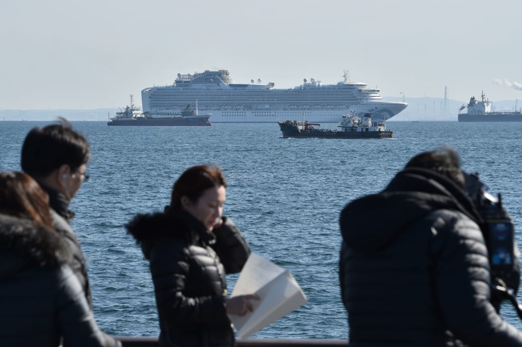 The Diamond Princess cruise ship (top,C) is seen off the port of Yokohama on February 5, 2020. - At least 10 people on a cruise ship quarantined off the coast of Japan have tested positive for the new coronavirus, Japan's health minister said on February 5.