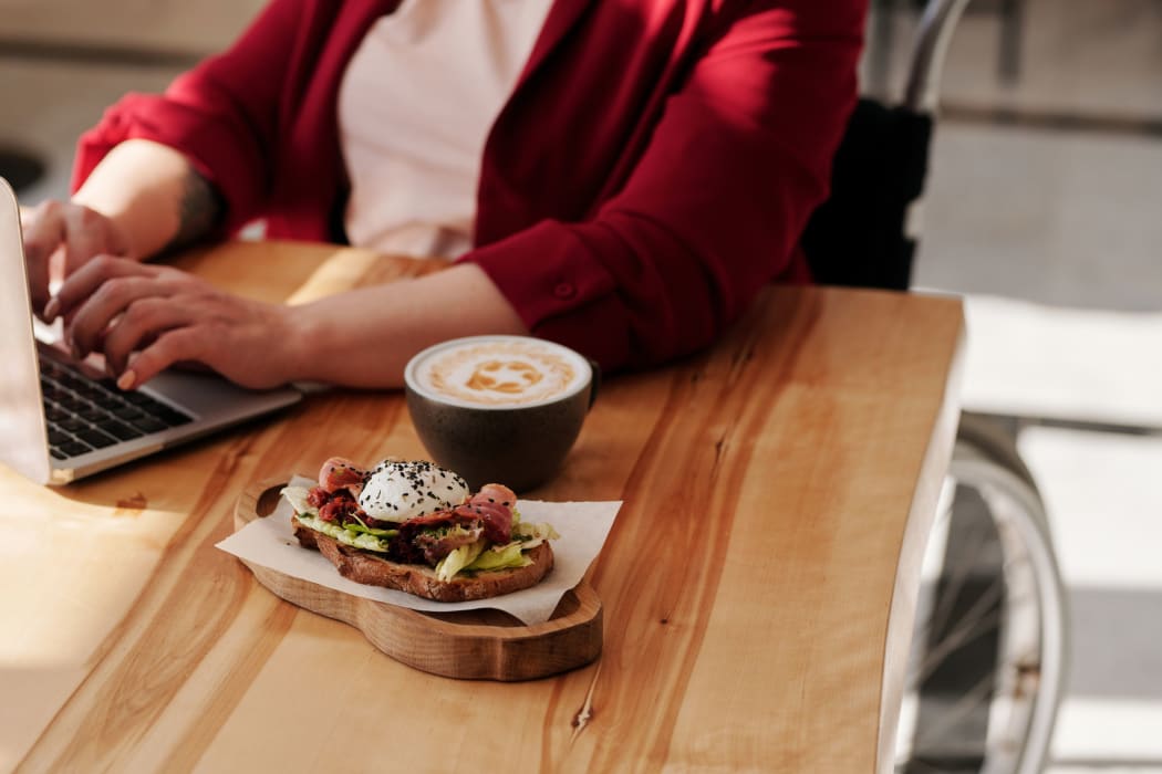 woman in wheelchair with coffee and food
