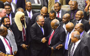 Sir Michael Somare (centre, red tie) is congratulated by Peter O'Neill and other MPs on his last attendance in the Papua New Guinea parliament, 4 April 2017.