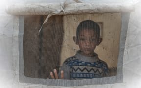 A boy looks out from a tent at a makeshift camp sheltering displaced Palestinians after heavy rains in the Zeitoun neighbourhood of Gaza City on 11 December, 2025.