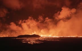 A photo taken during the night from August 22 to 23, 2024 shows lava and smoke erupting from a volcano near Grindavik on the Icelandic peninsula of Reykjanes. A new volcano erupted on the Reykjanes peninsula in southwestern Iceland on August 22, 2024, spewing hot lava into the air in the sixth eruption to hit the region since December 2023, authorities said. (Photo by Ael Kermarec / AFP)