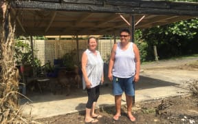 Tina Daly at left and Moana Matapo and the fire damaged car port — all that was left after a fire destroyed their home and contents.