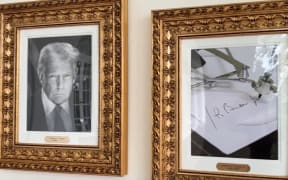 A screenshot from a video posted by a White House official showing a portrait of Donald Trump next to a Joe Biden signature produced by an autopen machine.