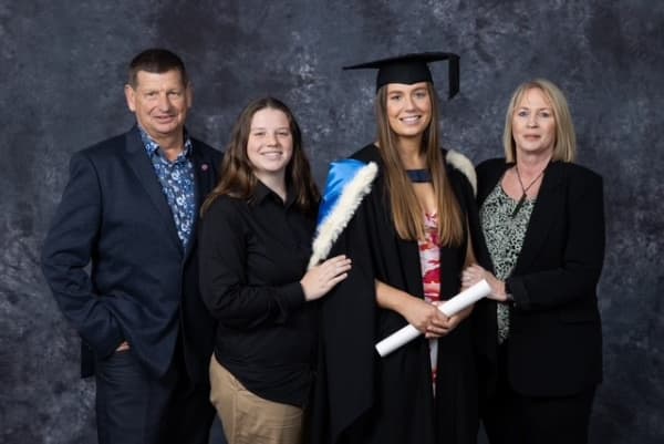Kath Cross stand with her daughters and husband at her daughter's graduation.