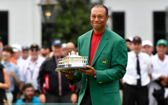 Tiger Woods celebrates with the green jacket and trophy after winning The Masters golf tournament at Augusta National Golf Club.