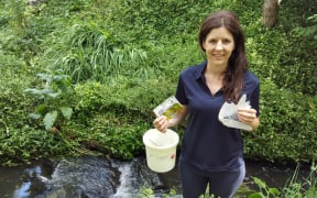 Amanda Valois in Hamilton's Donny Park holding mostly plastic rubbish she picked up along the 100 metre walk from the road to the stream.