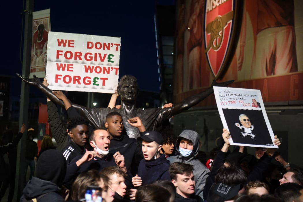Supporters protest next to the statue of Tony Adams against Arsenal's US owner Stan Kroenke.