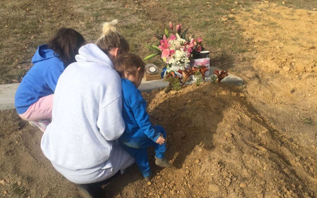 Amy and her two children at Peter's grave