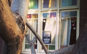 A poster in a window saying "seeking asylum is a human right"