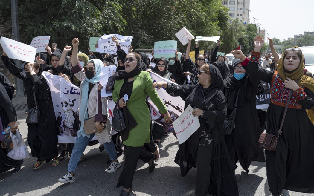 Afghan women hold placards as they march and shout slogans 'Bread, work, freedom' during a womens' rights protest in Kabul on 13 August 2022.