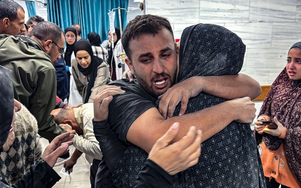 EDITORS NOTE: Graphic content / People comfort each other inside the Kamal Adwan hospital, as victims receive medical care following an Israeli strike that hit an area near the medical establishment in Beit Layia in the northern Gaza Strip early on November 21, 2024, reportedly leaving dozens of people killed or unaccounted for. (Photo by AFP)