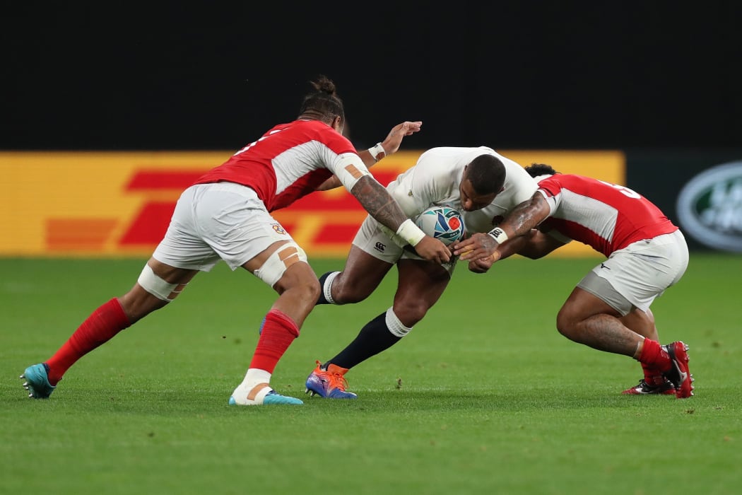 England's Kyle Sinckler tackled by Tongan defenders.