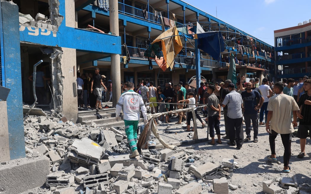 Palestinians survey the damage following the Israeli military bombardment of the UNRWA (United Nations Relief and Works Agency for Palestine Refugees) run Abu Oreiban school, turned shelter, where internally displaced Palestinians are living, in the Nuseirat refugee camp, in the central Gaza Strip on July 14, 2024, amid the ongoing conflict between Israel and the Palestinian Hamas militant group. 

 (Photo by Eyad BABA / AFP)