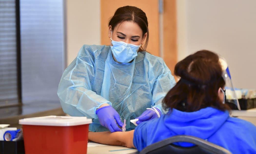 A phlebotomist draws blood during a Covid-19 antibody testing site on February 17, 2021 in Pico Rivera, California.