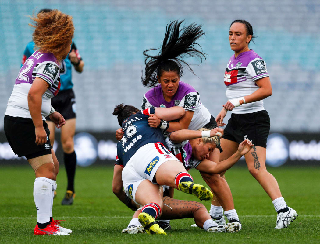 Louisa Gago (c) helps execute a tackle during the Warriors NRL Women's Premiership match against the Sydney Roosters.