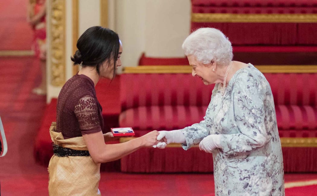 Elizabeth Kite  receives her award from the Queen.