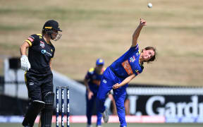 Eden Carson of Otago bowling, with Wellington's Sophie Devine backing up.