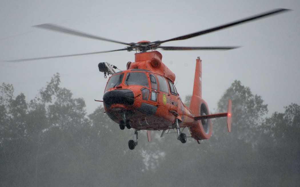 An Indonesian search and rescue team helicopter carrying a victim and recovered items from AirAsia QZ8501 prepares to land on 1 January 2015.