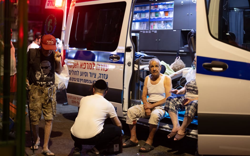 Israeli medics treat people wounded in Iran's missile attack in the city of Bat Yam, a subrub of Tel Aviv, on June 15, 2025. The exchanges of strikes between Iran and Israel continue following Israel's attack on numerous locations in Iran in early hours of June 13. (Photo by Faiz Abu Rmeleh / Middle East Images via AFP)