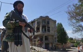 A Taliban fighter stands guard in front of a Sikh temple after it was attacked by gunmen in Kabul on 18 June.