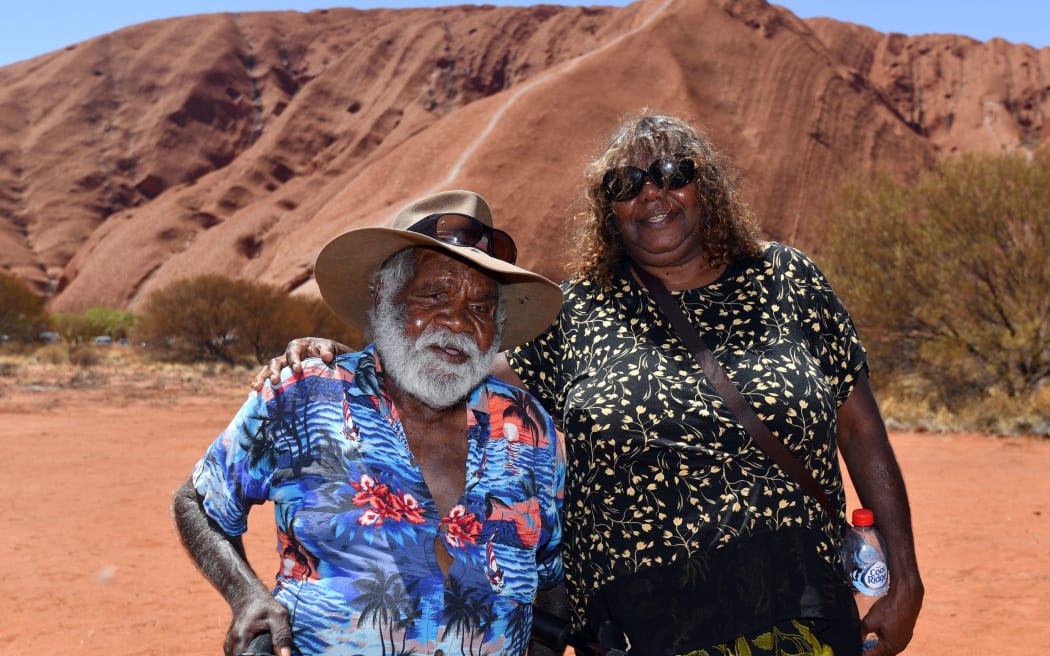 Traditional Aboriginal owners of Uluru-Kata-Tjuta, the Anangu, gather in front of the Uluru, also known as Ayers rock, after a permanent ban on climbing Uluru at the Uluru-Kata Tjuta National Park in Australia's Northern Territory on October 26, 2019. -