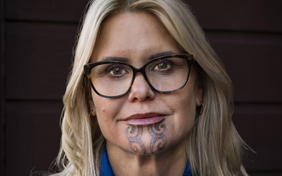 Dr Hinemoa Elder wearing a blue scarf, smiling at the camera.