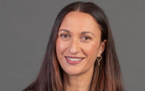 Kara Rickard smiling in front of grey background