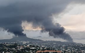 FILE - Smoke rises during protests in Noumea, New Caledonia, on May 15, 2024. Global nickel prices have soared since deadly violence erupted in the French Pacific territory of New Caledonia. (AP Photo/Nicolas Job, File)