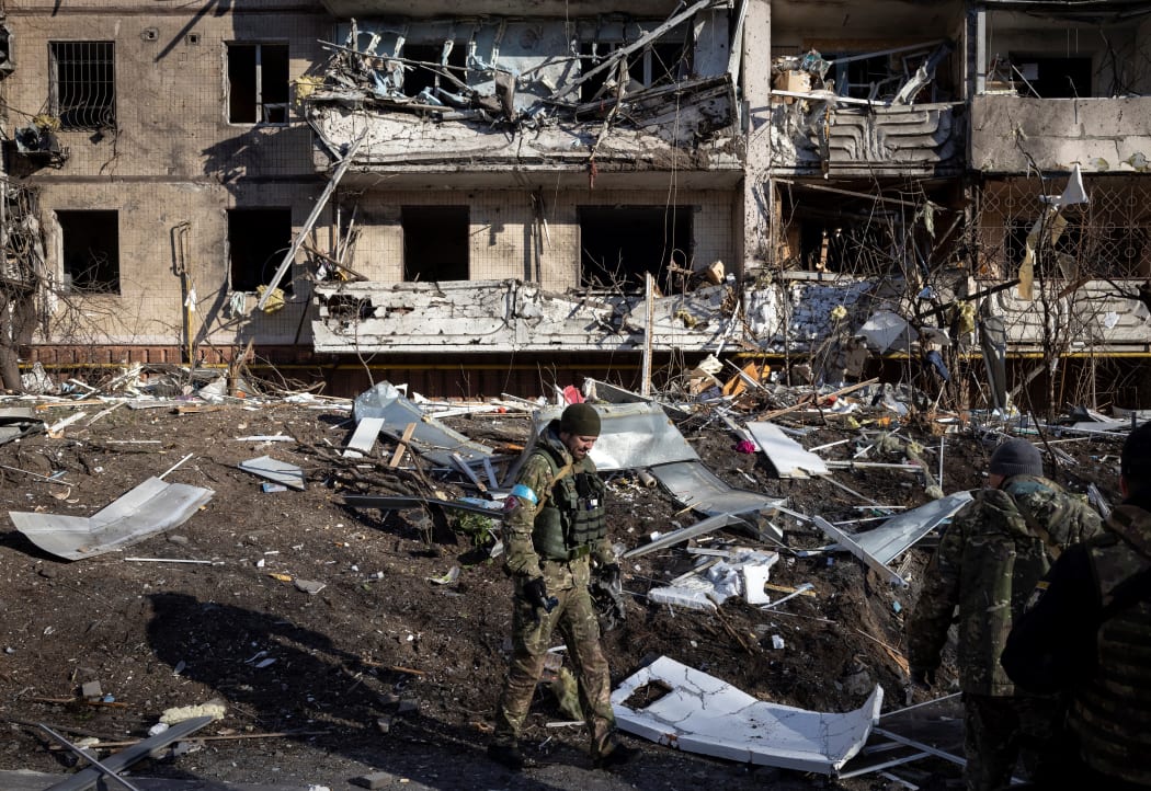 A Ukrainian soldier inspects the rubble of a destroyed apartment building in Kyiv on 15 March 2022.