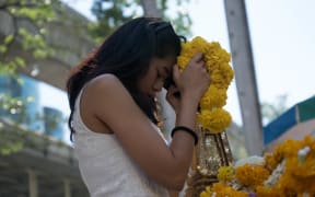 A woman prays at the reopened Erawan Shrine in Bangkok.
