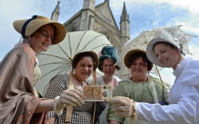 People in period costume pose with on the Bank of England's new ten pound notes, featuring author Jane Austen, during its launch at Winchester Cathedral in Winchester, southern England, on July 18, 2017.