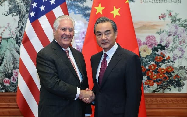 US Secretary of State Rex Tillerson shakes hands with Chinese Foreign Minister Wang Yi.