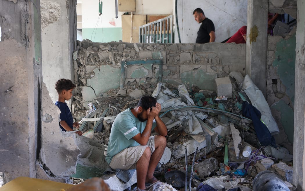 A man reacts as he sits amid the rubble at the Fahmi Al-Jarjawi School in Gaza City on 26 May, 2025, following an Israeli strike.