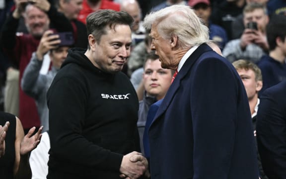 Tesla and SPaceX CEO Elon Musk and US President Donald Trump shake hands as they attend the men's NCAA wrestling competition at the Wells Fargo Center in Philadelphia, Pennsylvania, on March 22, 2025. (Photo by Brendan SMIALOWSKI / AFP) / ALTERNATE CROP