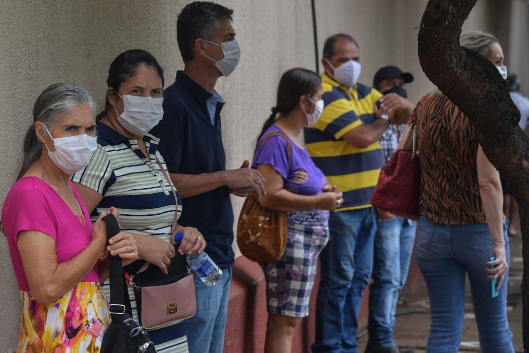 Residents line up to receive the Coronavac vaccine against Covid-19, in Serrana, Brazil, on February 17, 2021.