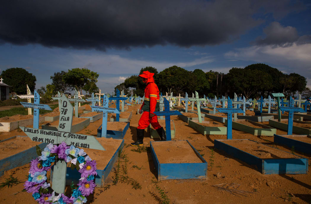 A gravedigger walks among graves of COVID-19 victims at the Nossa Senhora Aparecida cemetery in Manaus, Amazonas state, Brazil.