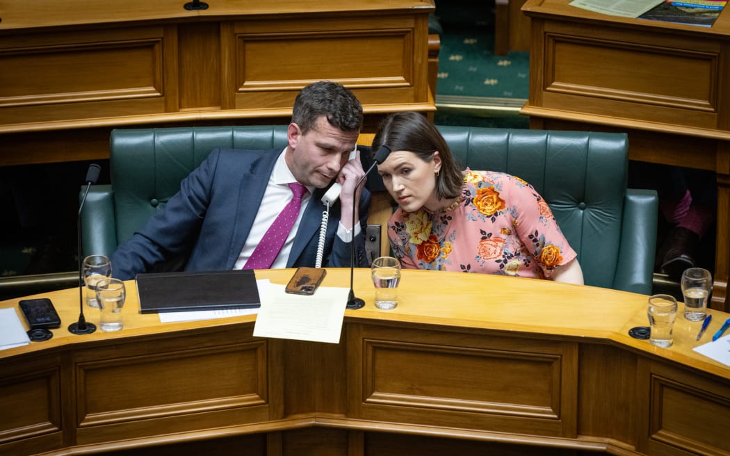 ACT Leader David Seymour and his Deputy Brooke van Veldt share a phone.