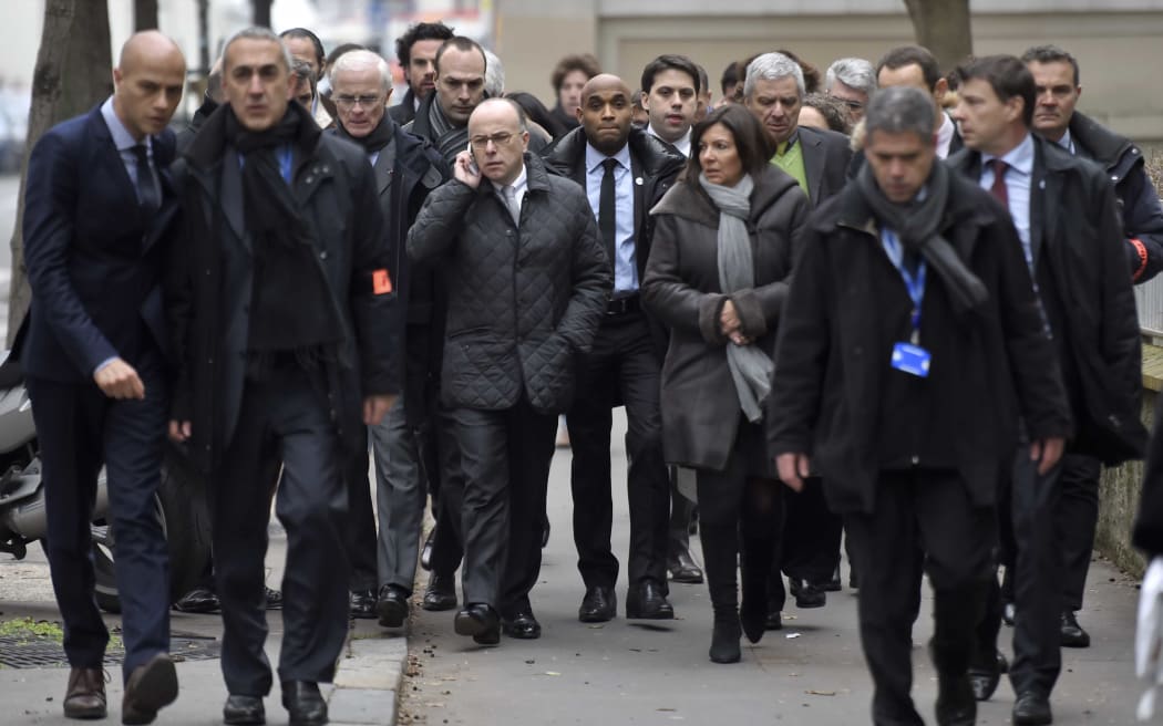 France's interior minister Bernard Cazeneuve (C, L) and Paris' Mayor Anne Hidalgo (C, R) arrive at the headquarters of the French satirical newspaper Charlie Hebdo.