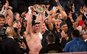 New Zealand heavyweight Joseph Parker holds up the WBO belt alongside his team.