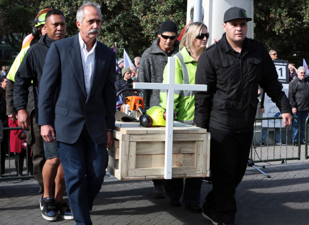 Families and colleagues of forestry workers killed at work protest at Parliament.