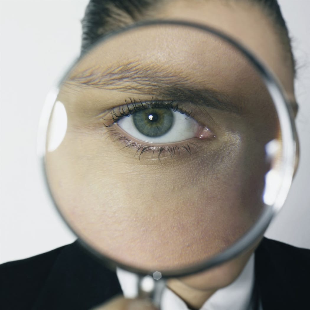 Portrait woman posing, with magnifying glass in front of her eye. (Photo by Double Touch / Photononstop / Photononstop via AFP)