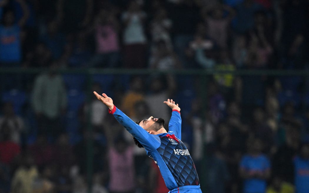 Afghanistan's Rashid Khan celebrates after taking the wicket of England's Mark Wood during the 2023 ICC Men's Cricket World Cup one-day international (ODI) match between England and Afghanistan at the Arun Jaitley Stadium in New Delhi on October 15, 2023.